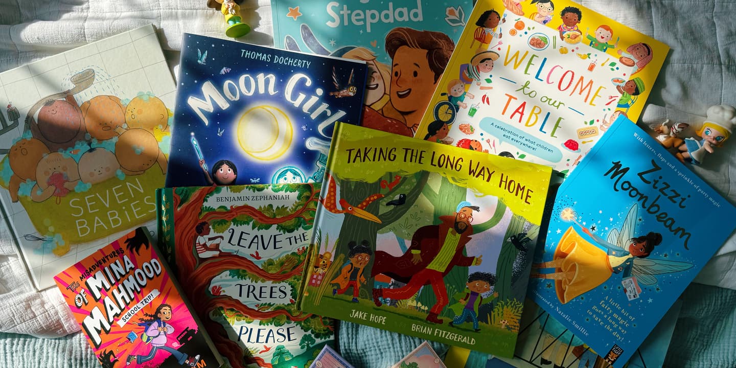 A selection of the best diverse children's books published in the UK in April 2025 are photographed, strewn over a carpet in dappled sunlight.