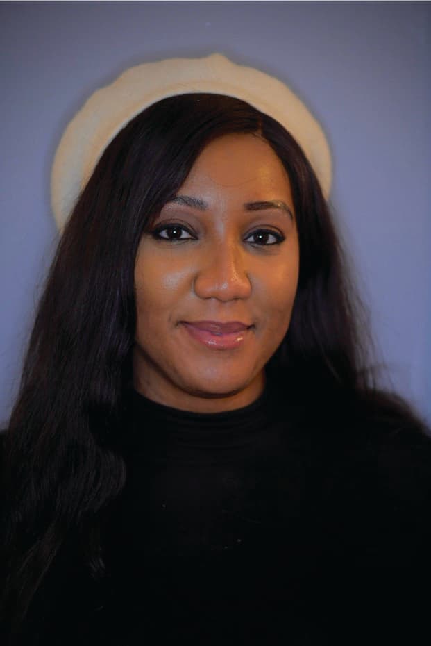 Mel Nyoko, a Black woman in her 30s, smiles beatifically in front of a background that gives the effect of a halo. 