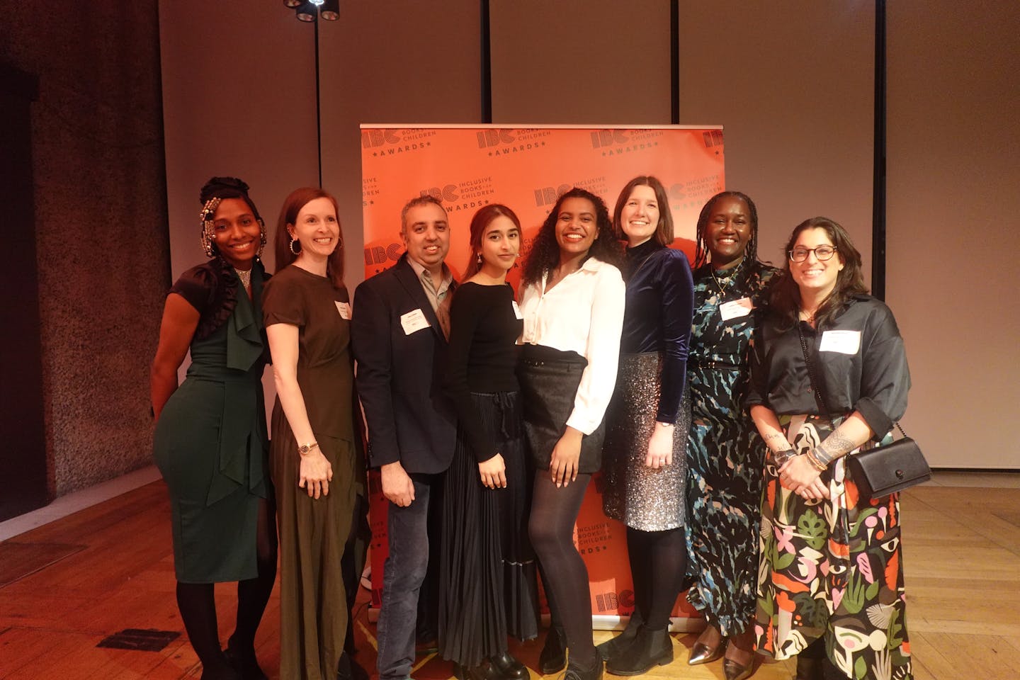 A team photo from the IBC Awards 2024 showing (left to right) Kea, Sarah Jake, Jayna, Kristel, Sophie, Fabia and Sinead, standing in front of an IBC Awards banner at the Barbican.